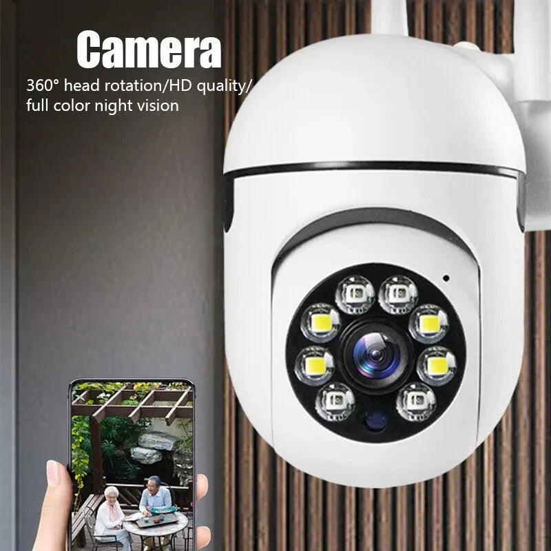 White security camera with LED lights and a smartphone displaying a video feed, on a dark background.