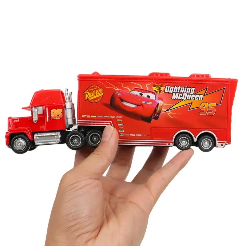 Red toy truck with Lightning McQueen design held by a hand on a white background