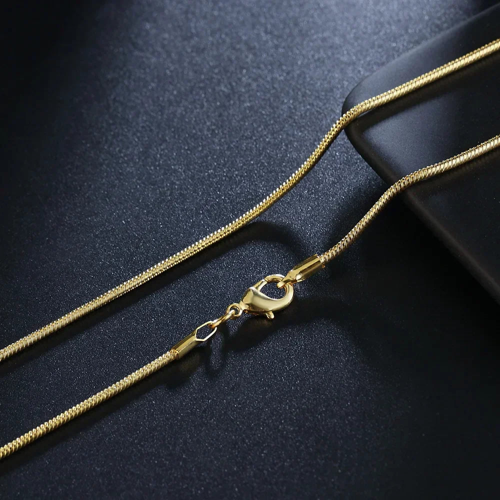 Gold chain necklace with clasp on a dark background