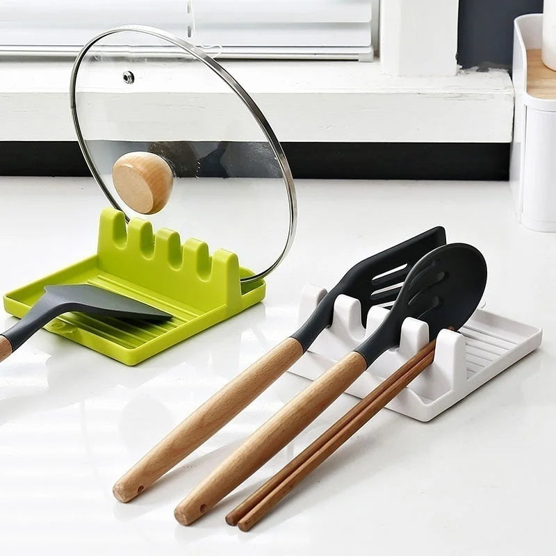 Set of kitchen utensils including spatulas and ladles on a white surface with a green and white utensil holder.