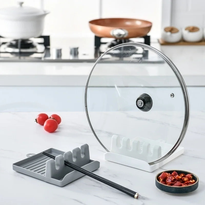 Glass lid on a stand with kitchen tools and ingredients on a countertop
