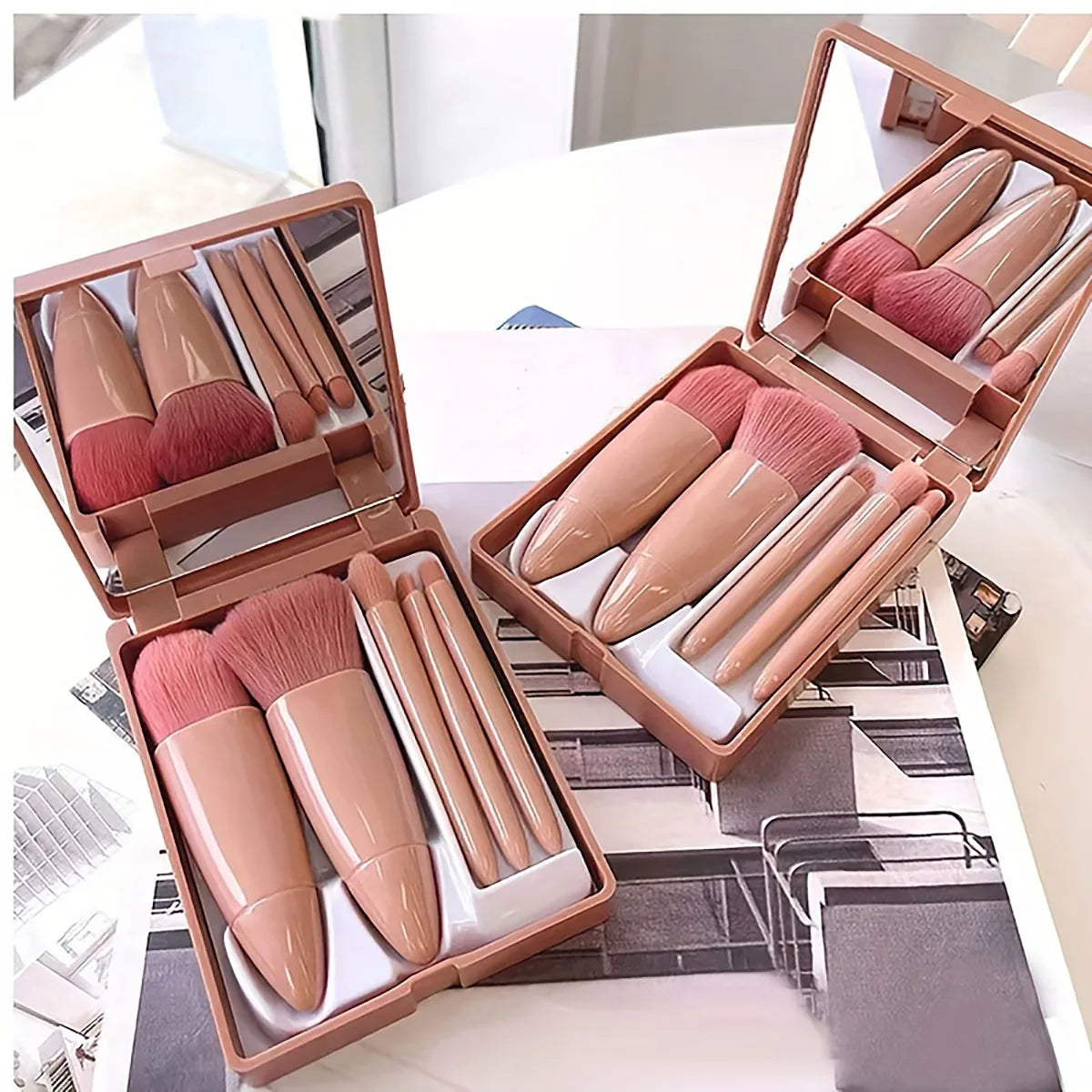 Set of makeup brushes in a rose gold case on a white surface.