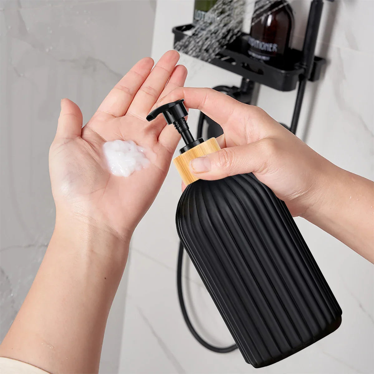 Person holding a black soap dispenser with soap on hands, shower in background