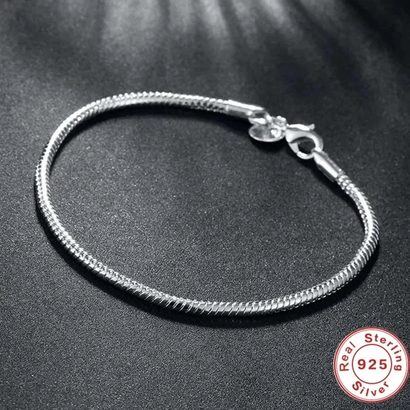 Silver bracelet on a dark surface with 'Sterling Silver 925' stamp.