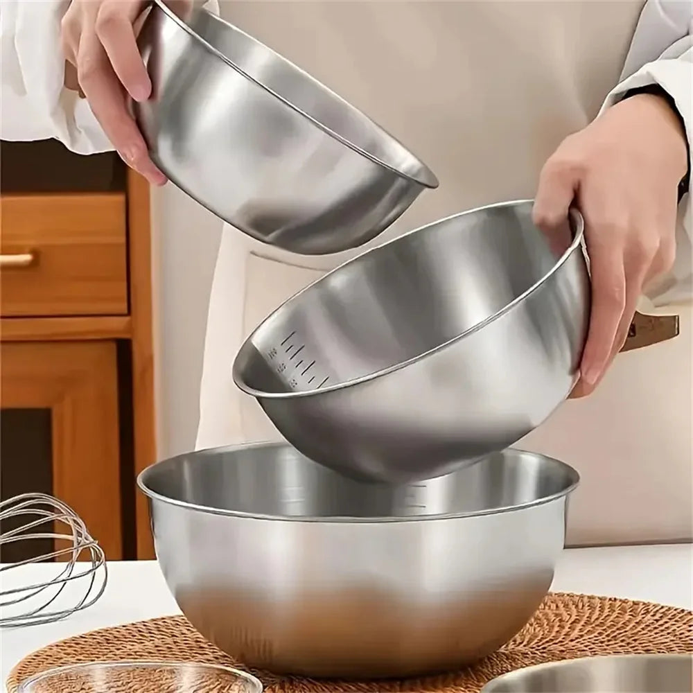 Three stainless steel mixing bowls stacked on a kitchen counter.