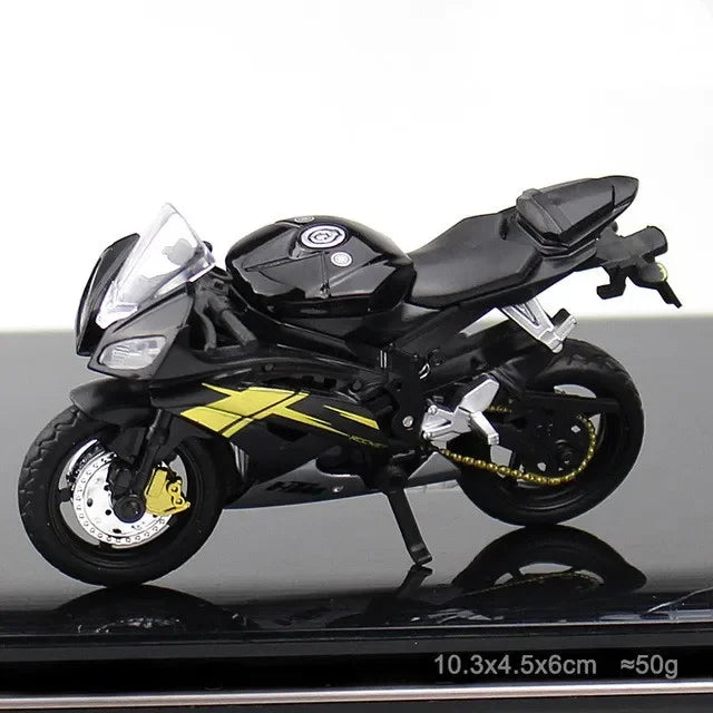Black motorcycle model with yellow accents on a reflective surface