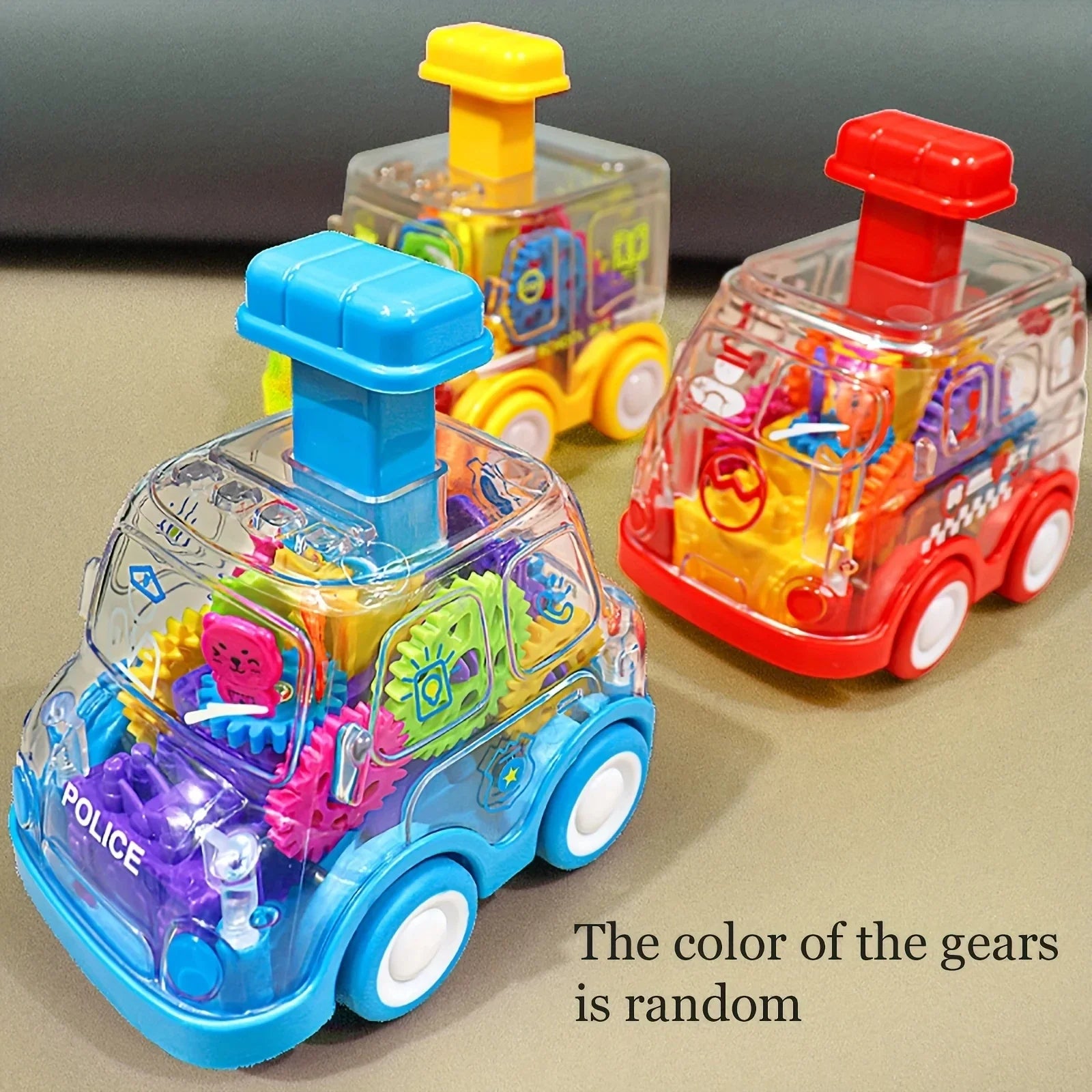 Three colorful toy vehicles with transparent bodies on a beige surface.