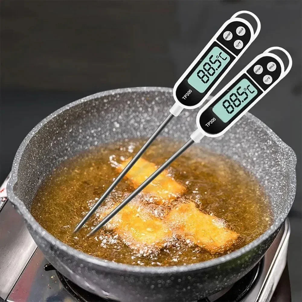 Two digital thermometers inserted into frying food in a pan with oil.
