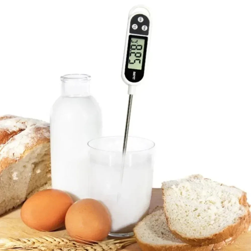Digital thermometer in a glass of milk with bread, eggs, and a bottle in the background