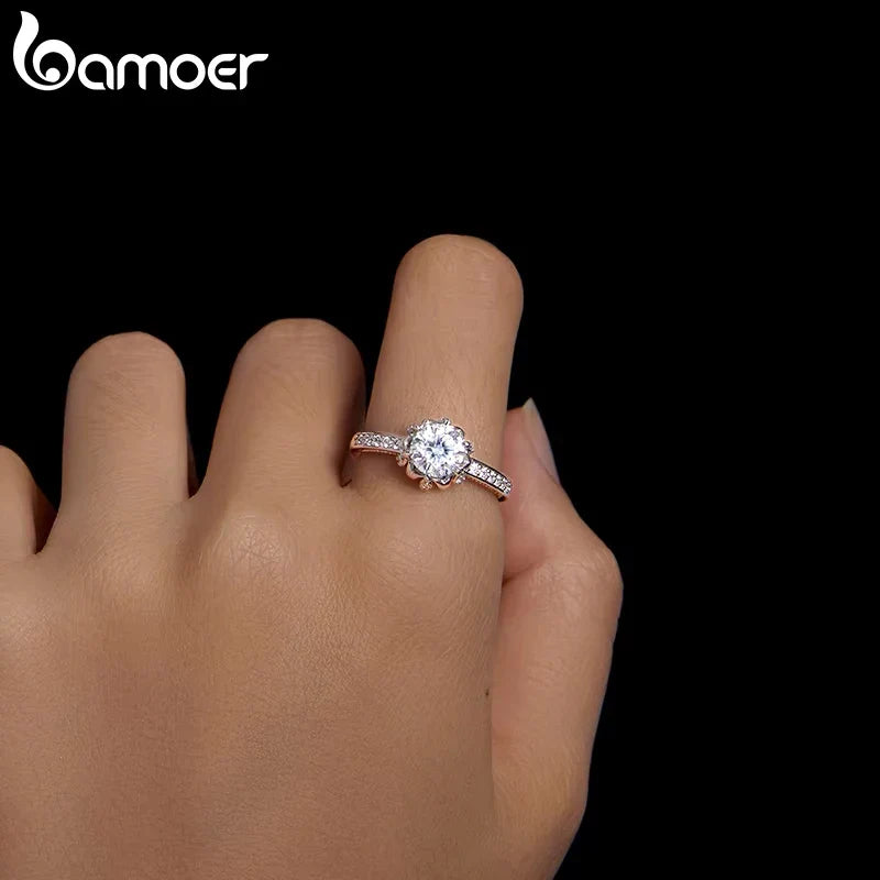 Diamond ring on a hand with 'bamoer' branding in the corner.